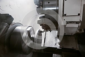 Rotation of aluminium part on CNC metalworking machinery. Working of milling machine with Control Numerical Computer.