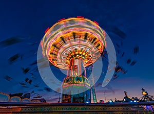 A rotation chain carousel illuminated with different bright colors. photo