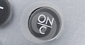 Rotation. Close-up of black button with ON symbol.