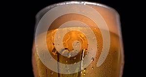 rotation of Cold Light Beer in a glass with water drops. Craft Beer close up.