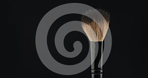 Rotation of a cosmetic brush on a black background.