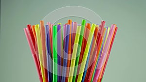 Rotation of many multi-colored plastic disposable straws for cocktails.