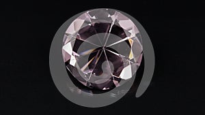 Rotation of a pink transparent rhinestone on a black background.