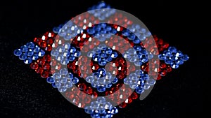 Rotation of red and blue squares made of rhinestones.