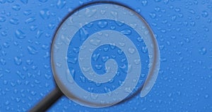 Rotation. Wind blowing on water drops on a blue background. Movement of a drop of water through a magnifying glass