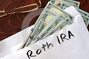 Roth IRA written on an envelope with dollars.