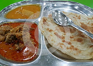 Roti Canai with Lamb Curry on silver tray photo