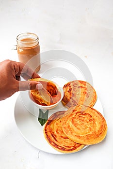 Roti canai and teh tarik. paratha bread or canai bread or roti maryam, favorite breakfast dish. served on plate.