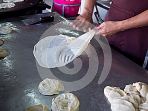 Roti Making, roti thresh flour by roti maker with oil. Indian traditional street food