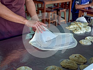 Roti Making, roti thresh flour by roti maker with oil. Indian traditional street food