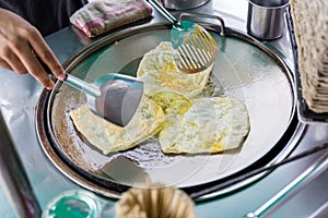 Roti Making, roti thresh flour by roti maker with oil. Indian traditional street food. Thai Pancake Banana And Egg .