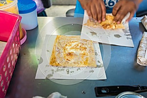 Roti Making, roti thresh flour by roti maker with oil. Indian traditional street food. Thai Pancake Banana And Egg . Thai Street