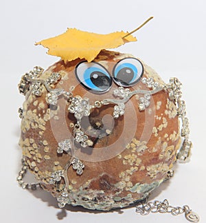 Rotten Apple with eyes adorned with jewels, bad man concept, on white background