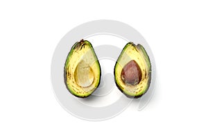 A rotten avocado cut in half on white background