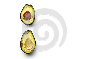 A rotten avocado cut in half on white background. One slice with core