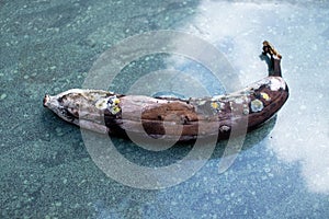 Rotten banana, mouldy fruit on marble background