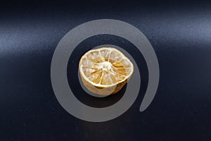 Rotten lime fruit on seen from above on a dark background