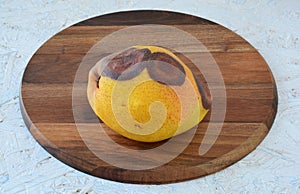 Rotten pear on a chopping board