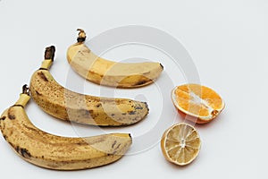 Rotten ripe bananas, half bad orange and lemon. Excessive consumption, wasting money concept