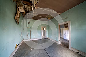 The rotting and decaying interior of an old kitchen in an abandoned home in Bannack Ghost Town. Ceiling is collapsing