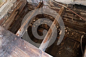 Rotton broken floor joists exposed during home renovation with flooded house foundations