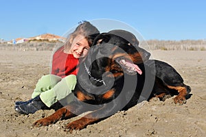 Rottweiler and child on the beach
