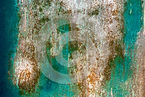 Rough and battered green paint texture on a rusted metal surface showing scratches.