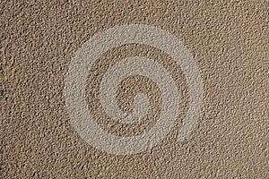 Rough bumpy brown concrete plaster.