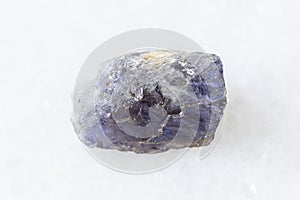 Rough Cordierite Iolite crystal on white marble