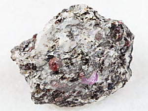 rough corundum crystals in gneiss stone on white