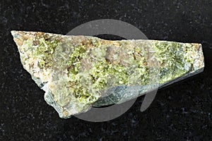 Rough crystal of green Vesuvianite stone on dark photo