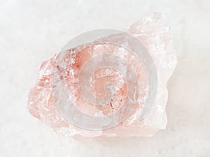 rough crystal of rose quartz gemstone on white