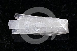 rough crystal of Scolecite gemstone on dark photo