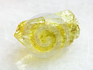 Rough crystal of yellow Apatite gemstone on white