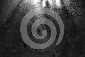 Rough, dark stone wall lit above by spotlight. Grunge background