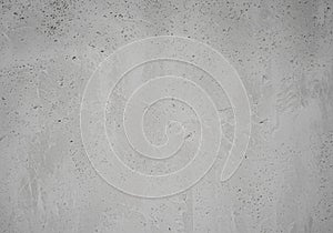 Rough gray concrete wall with a textured surface. The wall exhibits a slightly uneven pattern with