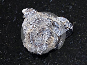 rough Ilmenite stone on dark granite background photo
