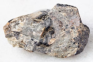 rough Nepheline stone with Ilmenite vein on white photo