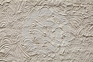 Rough plaster wall texture with chaotic semicircular grooves.