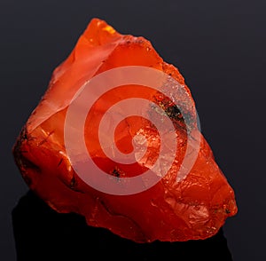 Rough red carnelian rock isolated on black