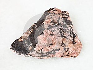 rough Rhodonite gemstone on white