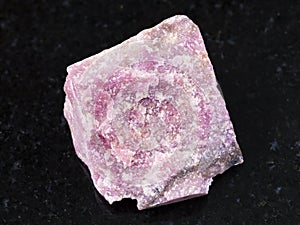 rough rhodonite stone on dark background