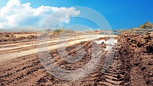 Rough road in the countryside. There are mud basins and wheels