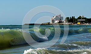 The rough sea. Big waves. The Black Sea coast, in Romania. Beachfront hotel in Costinesti resort