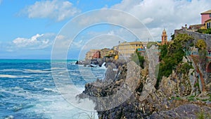 rough sea big waves crash on small port of Nervi in Genoa in Italian Riviera of liguria in beautiful sunny day