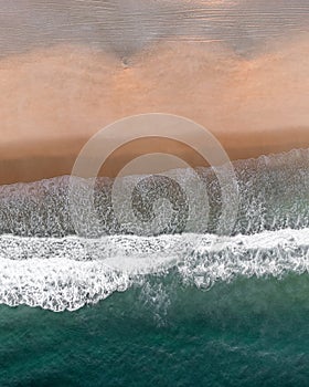 Rough sea with foamed waves interwoven with colored skyscape in Portugal