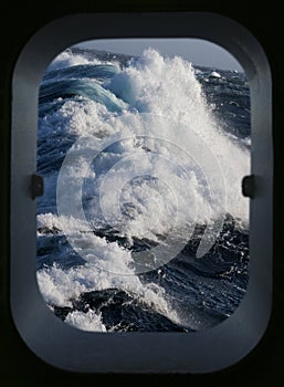 Rough sea through a ships porthole photo