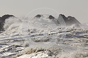 Rough sea waves covering rocks