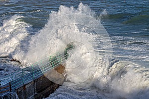 Rough Sea Waves Crashing Over a Pier, mediterranean sea, ligurian coast, Italy.