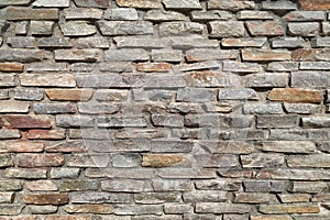 Rough stone wall made of ceramic tiles of different sizes and colors.